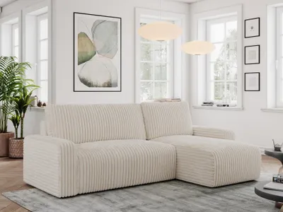 A modern living room with a beige cord sofa, plants, and artwork.