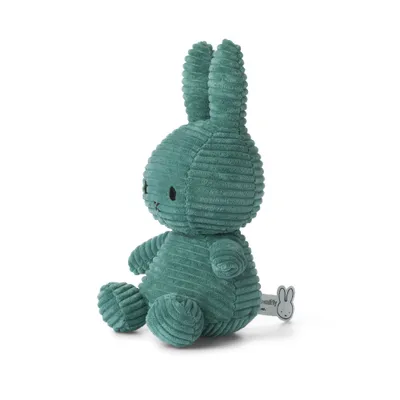 A green corduroy Miffy bunny toy sitting on a white background.