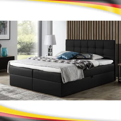 A black boxspring bed with a tufted headboard is shown in a bedroom setting.