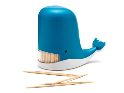 A blue whale-shaped toothpick dispenser with toothpicks scattered in front of it, on a white background.
