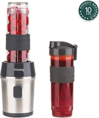 A H.Koenig mini smoothie maker with two portable bottles, one filled with strawberries and the other with a red smoothie.