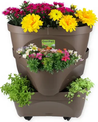 A tiered planter filled with colorful flowers and green plants, set against a white background.