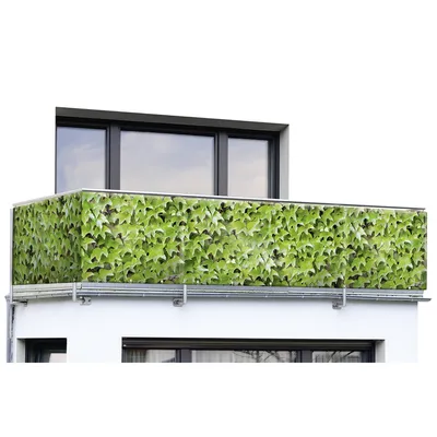 A balcony railing covered with a green ivy pattern screen.