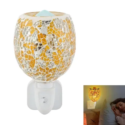 A mosaic-patterned electric aroma diffuser plugged into a wall socket, with a smaller inset image showing it in use in a bedroom at night.