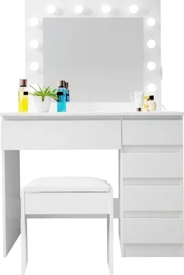 A white vanity table with a mirror and lights, along with a matching stool and some cosmetic items.