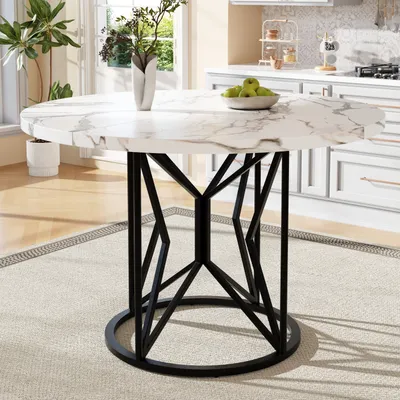 A round marble-top dining table with a black metal base, set in a bright kitchen or dining area.