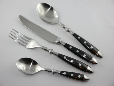 A set of four cutlery pieces arranged diagonally on a white background.