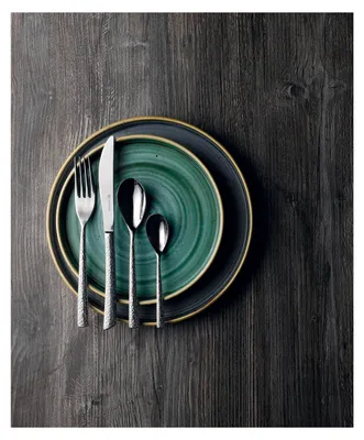 A set of cutlery and plates arranged on a dark wooden surface.