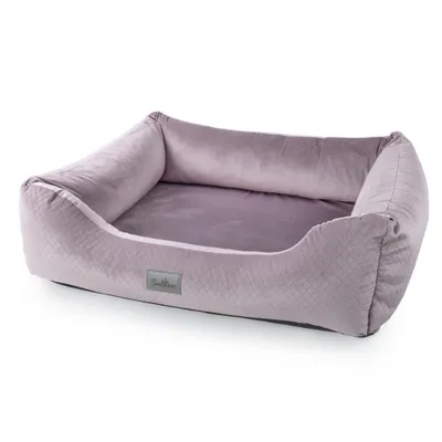 A light pink dog bed with raised sides is shown against a white background.