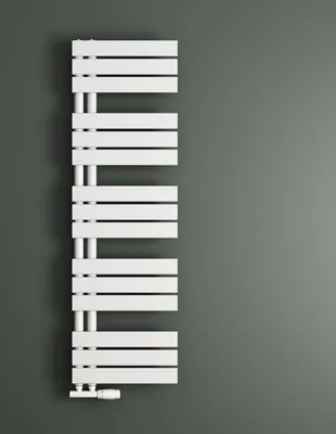 A white radiator is mounted on a gray wall.