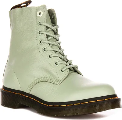 A single sage green Dr. Martens boot is shown against a white background.