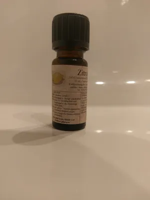Kleine braune Flasche mit einem schwarzen Verschluss. Auf dem Etikett steht "Zitrone".