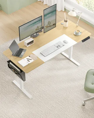 A modern home office setup with a standing desk, monitors, laptop, and chair.