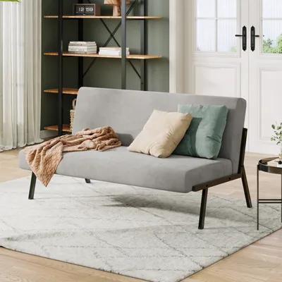 A modern living room setting with a gray sofa, throw blanket, and decorative pillows.