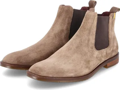 A pair of beige suede Chelsea boots are shown against a white background.