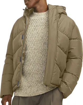 A man wearing a puffer jacket and a sweater.