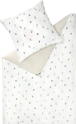 A flat lay of a duvet cover and a pillowcase with a small-scale pattern of skiers.