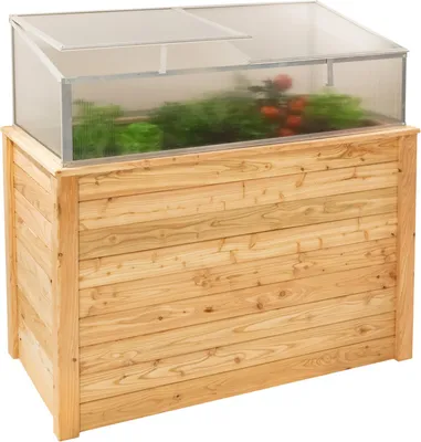 A wooden raised garden bed with a clear plastic greenhouse top.