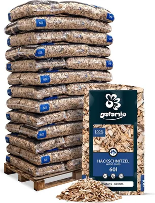 A pallet stacked with bags of wood chips, with a single bag in the foreground.