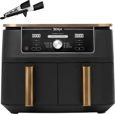 A black and gold Ninja Foodi Max Dual Zone air fryer with a pair of tongs above it, set against a white background.