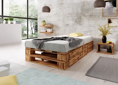 A bedroom with a pallet bed, nightstand, and window.