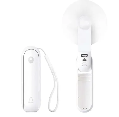 A white, foldable handheld fan and its base are shown against a white background. The fan is open, revealing its blades and a handle with USB ports and a button. The base is closed and has a strap attached.