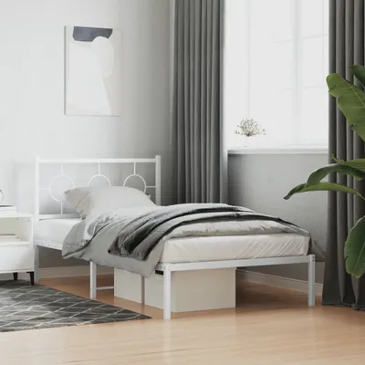A white metal bed frame with bedding in a bedroom setting.