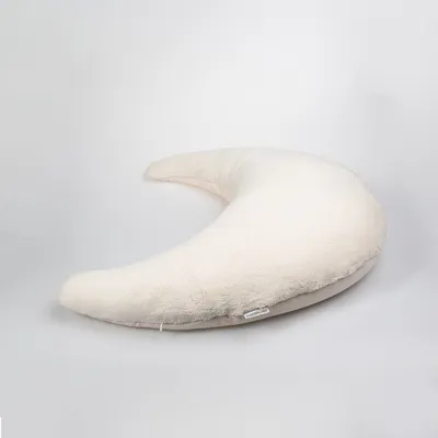 A cream-colored crescent-shaped pillow is shown against a white background.