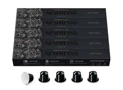 A stack of Nespresso Ristretto coffee capsule boxes and five individual coffee capsules.