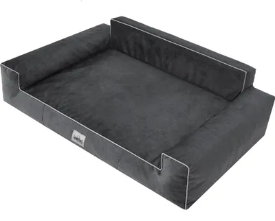 A dark gray dog bed with white piping and a small white tag on the front.