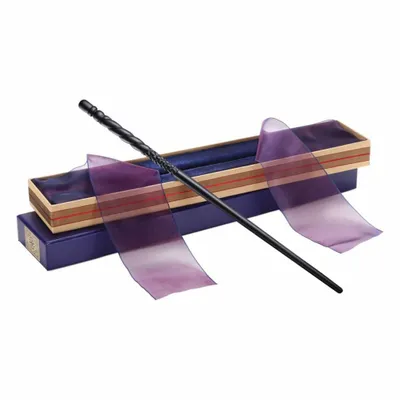 A black wand rests diagonally across a presentation box lined with purple fabric and trimmed with red and brown stripes. Purple sheer ribbons are draped over the box.