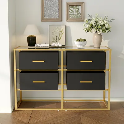 A sideboard with four drawers and a glass top, set against a plain white wall with framed pictures above it.