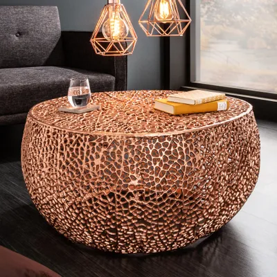 A living room setting with a copper coffee table, a sofa, and pendant lights.
