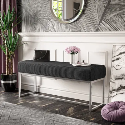 A stylish entryway with a bench, plant, and decorative items.