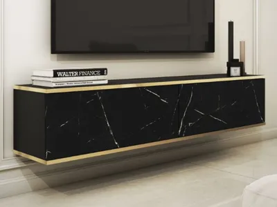 A modern, wall-mounted TV cabinet with a black marble finish and gold trim, shown in a living room setting.