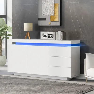 A modern white sideboard with blue LED lighting, decorated with a lamp and books, in a living room setting.