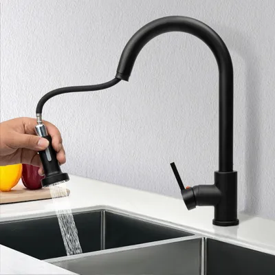 A black kitchen faucet with a pull-down sprayer is shown in use over a sink.