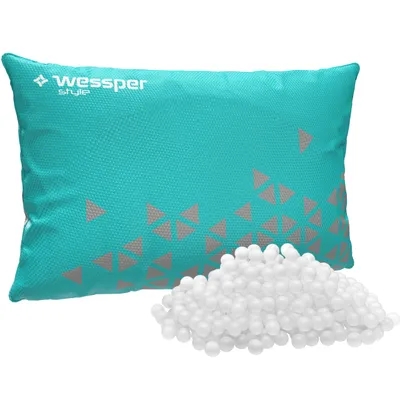 A teal pillow with gray triangle patterns and a pile of white beads next to it.