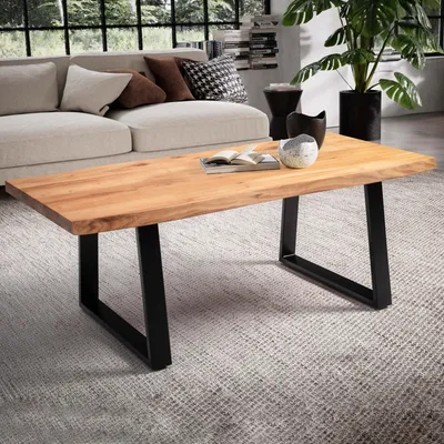 A living room scene with a couch, coffee table, and plant.