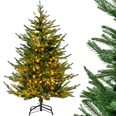 A pre-lit artificial Christmas tree on a white background, with a close-up of another Christmas tree branch on the right.