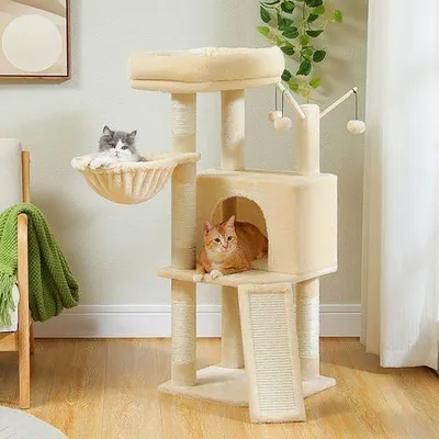 Two cats are playing on a multi-level cat tree in a room.