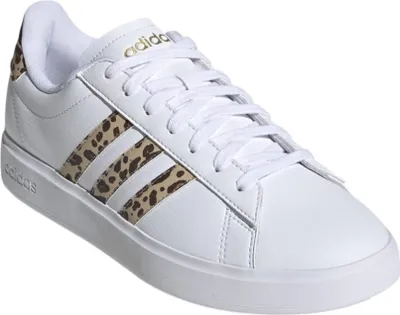 A white Adidas sneaker with leopard print stripes and gold accents.