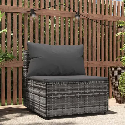 An outdoor patio scene with a rattan sofa and cushions, set against a wooden fence with string lights.