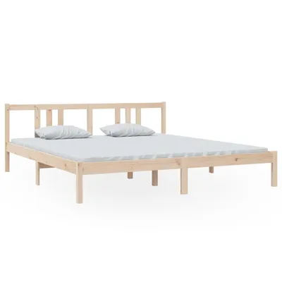 A wooden bed frame with two pillows on a mattress.