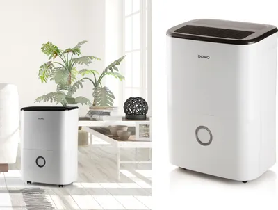 A white dehumidifier is shown in a bright, modern living room setting with plants and decorative items.