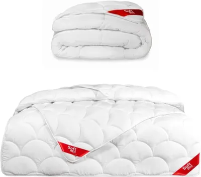 A folded and unfolded white duvet on a white background.