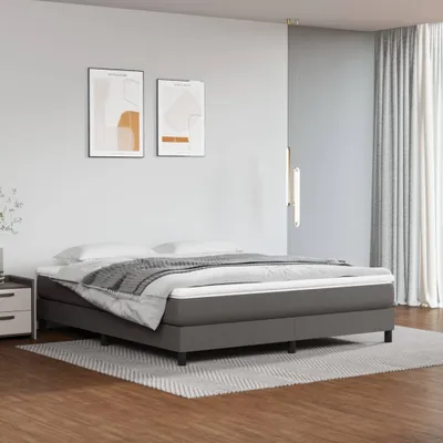 A bedroom scene with a bed, nightstand, and artwork on the wall.