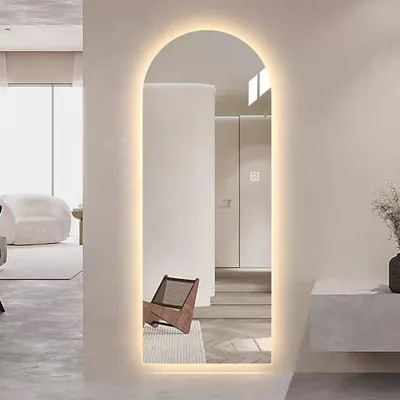 A modern interior with a large arched LED mirror.