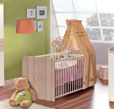 Babybett Kinderbett Winnie 70 x 140 cm in Sonoma Eiche mit orangefarbenem Himmel in Schlafzimmer-Gesamtansicht.