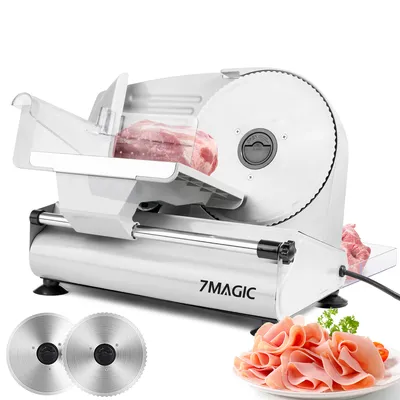 A white electric slicer with a piece of meat on the cutting board and a plate of sliced ham in the foreground.